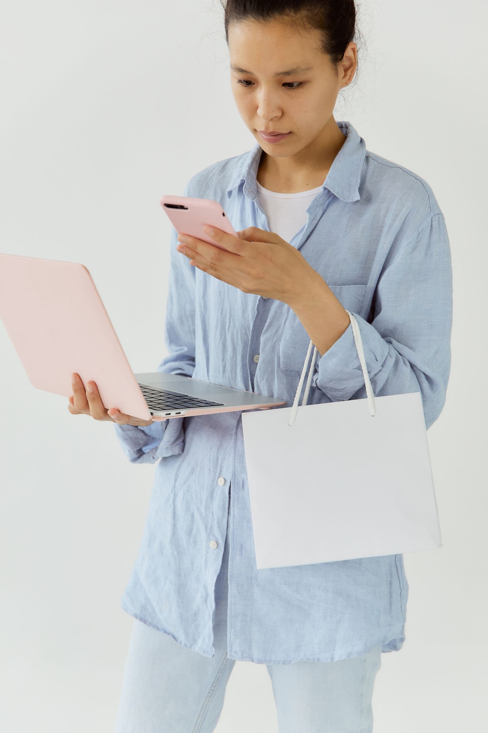 Customer using a smartphone and laptop while shopping
